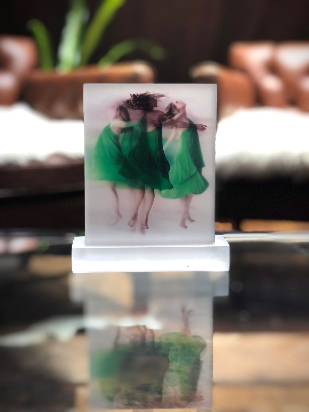 An artwork by Michelle Jader - "Embracing Impermanence" capturing the essence, featuring two girls in green dresses resting on a table.