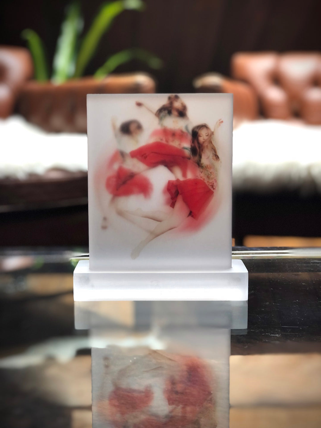 A digital print capturing the serene image of two girls sitting on a glass table, invoking a sense of calmness - Michelle Jader's "Calming Chaos".