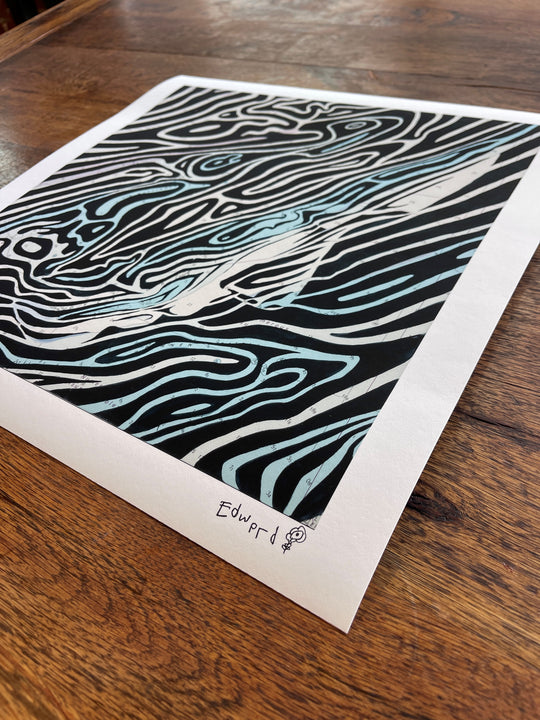 A visually stunning "The English Channel: Dover Straits" print by Ed Fairburn, capturing the raw power of a wave, showcased elegantly on a smooth wooden table.
