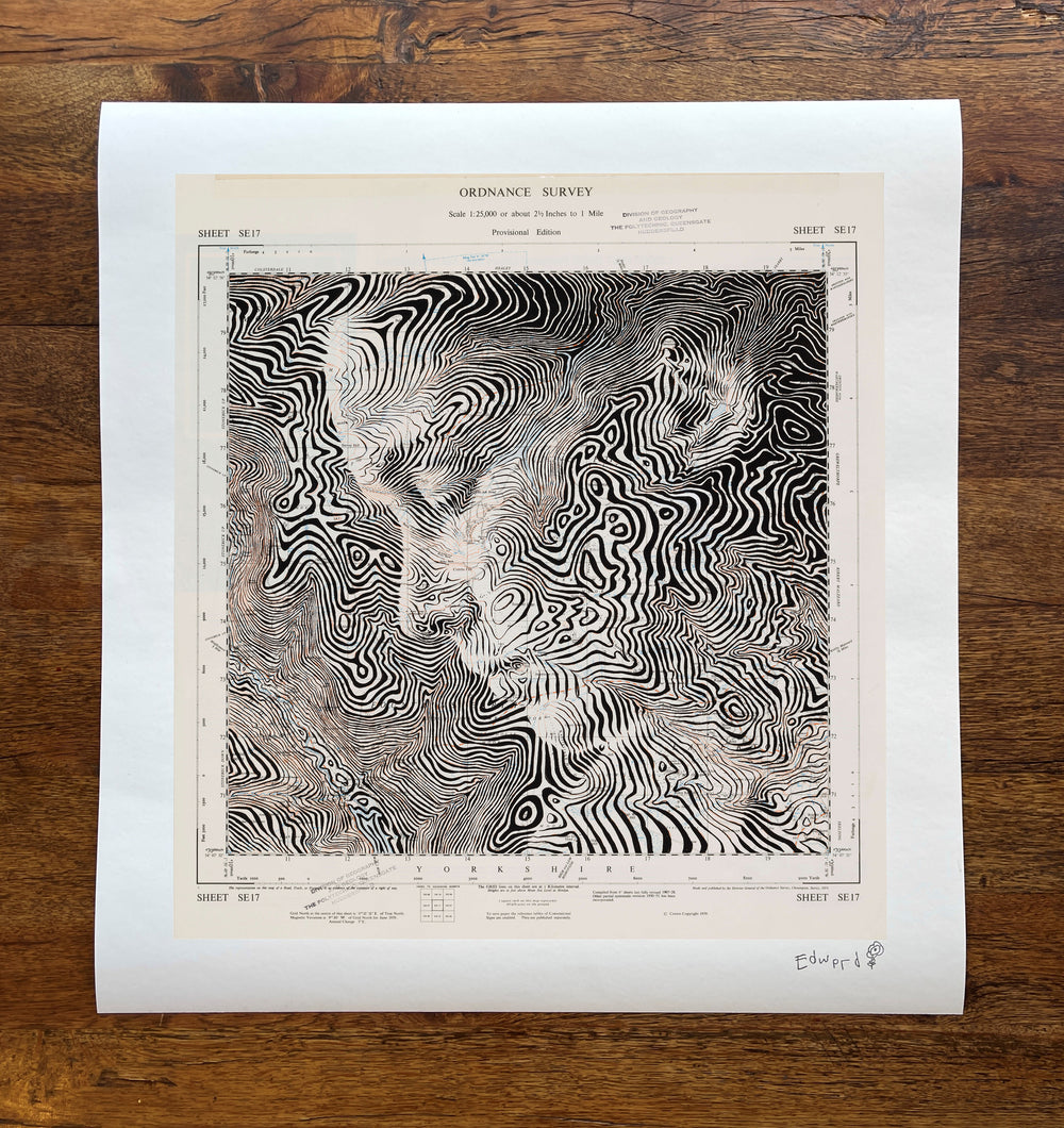 A print of a woman's face on a wooden table, created by Ed Fairburn in the United Kingdom, featuring Fountains Earth.