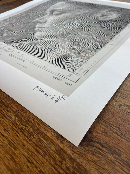 A black and white print by Ed Fairburn's "Fountains Earth, United Kingdom" on a wooden table in the United Kingdom.