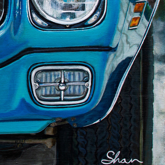 A close-up of a blue 1972 Pontiac Firebird Formula 400 M22’s headlight and grille, with visible tire and Shan Fannin’s signature, is available as a limited edition 28 x 40" giclée print by Shan Fannin.